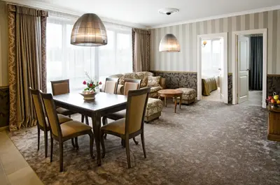 a living room with a table and chairs and a couch at Ursula Royal Apartments in Druskininkai