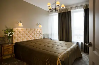 a bedroom with a large bed with a brown bedspread at Ursula Royal Apartments in Druskininkai