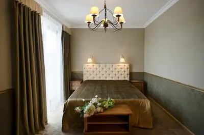 a bedroom with a bed and a chandelier at Ursula Royal Apartments in Druskininkai