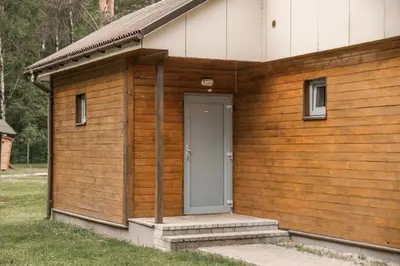 a wooden building with a gray door on it at Camping & Camper place Pasvalys in Pasvalys