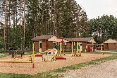 a playground with a slide in front of a house at Camping & Camper place Pasvalys in Pasvalys