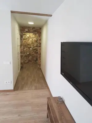a living room with a flat screen tv on a wall at Apartamentai Vilniaus Street II in Šiauliai