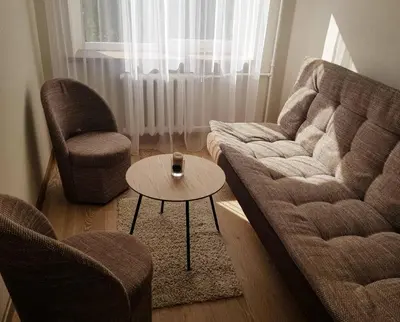 a living room with a couch and two chairs and a table at Apartamentai Vilniaus Street II in Šiauliai