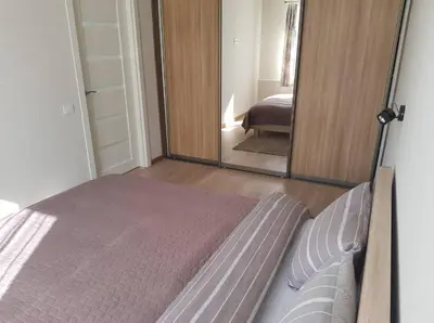 a bedroom with a bed and a large mirror at Apartamentai Vilniaus Street II in Šiauliai