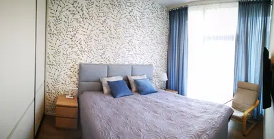 a bedroom with a bed with two blue pillows at Svajonių apartamentai in Druskininkai