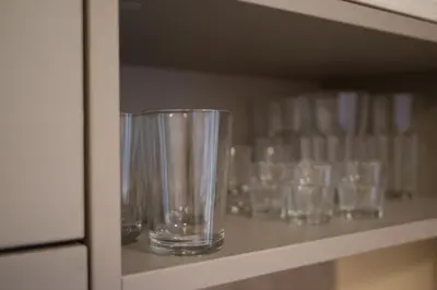 a row of empty glasses sitting on a shelf at Svajonių apartamentai in Druskininkai
