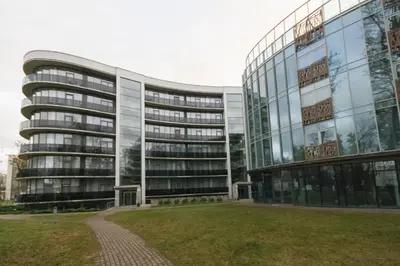an office building with a lawn in front of it at Svajonių apartamentai in Druskininkai