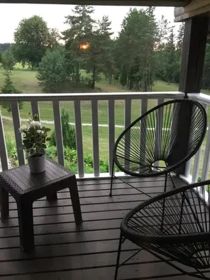 a porch with two chairs and a table with a potted plant at Economy rooms for 2-4 people in Anykščiai