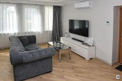 a living room with a couch and a flat screen tv at Roof terrace apartment in Panevėžys