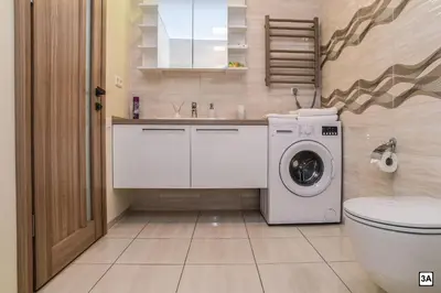 a bathroom with a toilet and a washing machine at Roof terrace apartment in Panevėžys
