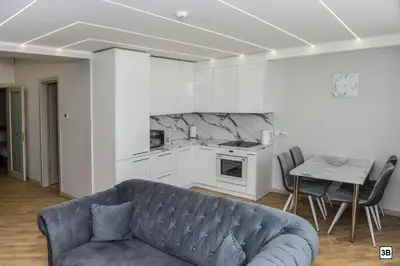 a living room with a couch and a kitchen at Roof terrace apartment in Panevėžys