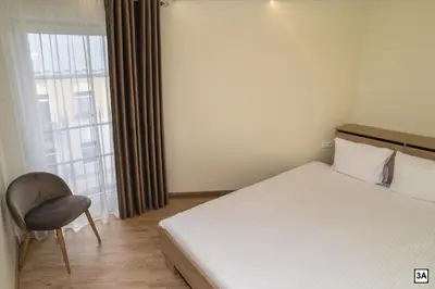 a bedroom with a bed and a chair and a window at Roof terrace apartment in Panevėžys