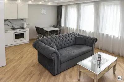 a living room with a couch and a table at Roof terrace apartment in Panevėžys