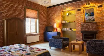 a bedroom with a brick wall with a bed and chairs at Luxury Kaunas Old Town Apartment in Kaunas