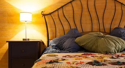 a bed with pillows and a lamp on a night stand at Luxury Kaunas Old Town Apartment in Kaunas