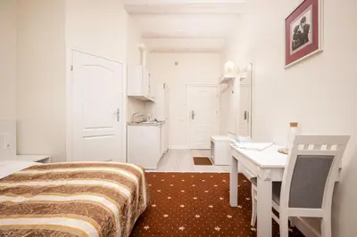 a white room with a bed and a desk and a table at Art Hotel in Druskininkai