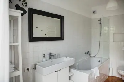 a bathroom with a sink and a tub and a mirror at SAKÀ Vacation House in Druskininkai