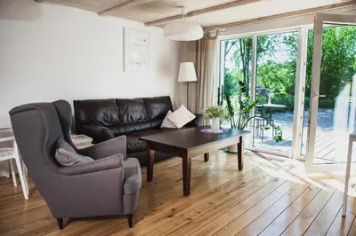 a living room with a leather couch and a table at SAKÀ Vacation House in Druskininkai