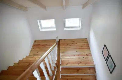 a staircase in a house with two windows at SAKÀ Vacation House in Druskininkai