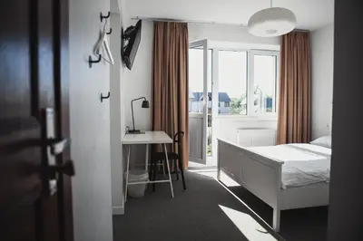a bedroom with a bed and a desk and a window at SAKÀ Vacation House in Druskininkai