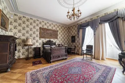 a living room with a chandelier and a rug at Burbiskio dvaras in Anykščiai