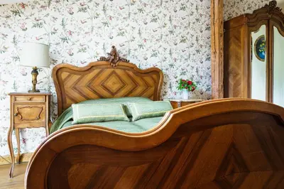 a bedroom with a wooden bed with a book on it at Burbiskio dvaras in Anykščiai