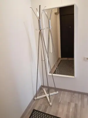 a mirror on a stand in front of a wall at J&E NERIES Apartment in Kaunas