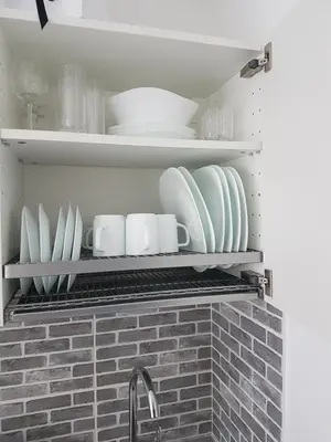 a kitchen shelf with plates and dishes on it at J&E NERIES Apartment in Kaunas