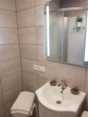 a bathroom with a sink and a mirror at J&E NERIES Apartment in Kaunas