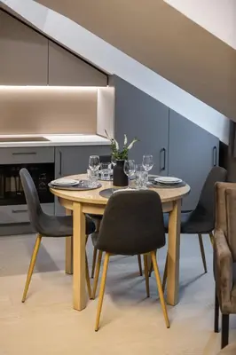 a dining room with a table with wine glasses on it at APARTAMENTAI LEMBERGAS in Vilnius