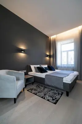 a bedroom with two beds and a couch and a window at APARTAMENTAI LEMBERGAS in Vilnius