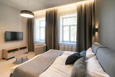 a bedroom with a large bed and a television at APARTAMENTAI LEMBERGAS in Vilnius