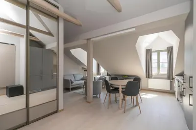 a dining room and living room with a table and chairs at APARTAMENTAI LEMBERGAS in Vilnius