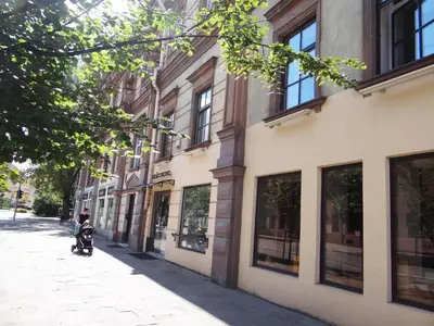 a person riding a scooter down a street next to a building at Little Provence Home in Vilnius