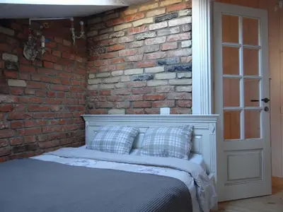 a bedroom with a brick wall and a bed at Little Provence Home in Vilnius