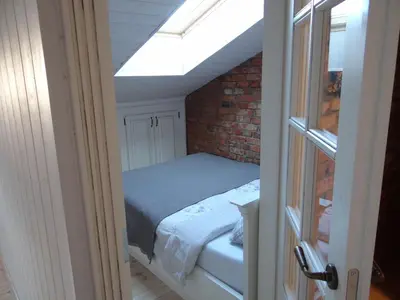 a bedroom with a bed and a skylight at Little Provence Home in Vilnius