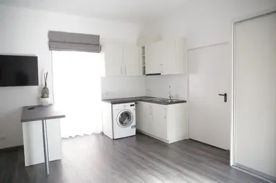 a white kitchen with a washing machine in it at Old Town Bakery in Marijampolė