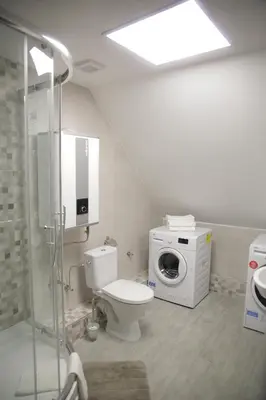 a bathroom with a toilet and a washing machine at Old Town Bakery in Marijampolė