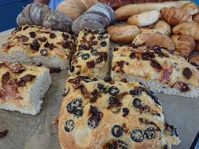 a table topped with slices of bread and pastries at Old Town Bakery in Marijampolė