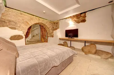 a bedroom with a large bed and a stone wall at Vilnius Old town apartments in Vilnius