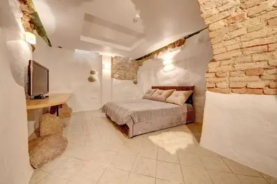 a bedroom with a bed and a stone wall at Vilnius Old town apartments in Vilnius