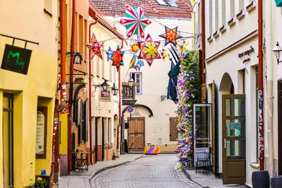 an alley with kites hanging from buildings in a city at Vilnius Old town apartments in Vilnius