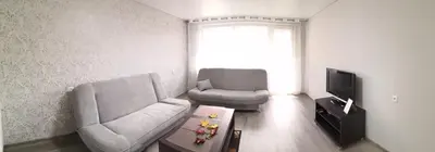 a living room with two chairs and a television at Apartamentai ,,ASTRA'' in Birštonas
