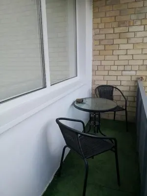 a small table and chairs in a room with a window at Apartamentai ,,ASTRA'' in Birštonas