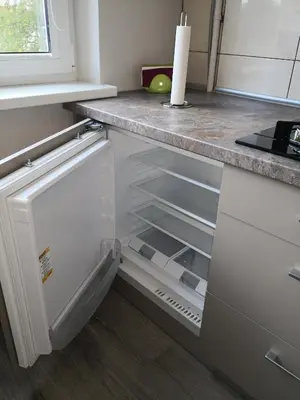 an empty refrigerator with its door open in a kitchen at Apartamentai ,,ASTRA'' in Birštonas