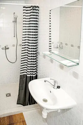 a white bathroom with a sink and a shower at Everena Guest House in Rokiškis