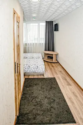 a room with two beds and a table and a window at Everena Guest House in Rokiškis