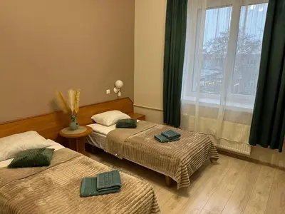 a hotel room with two beds and a window at Svečių namai RASA in Raseiniai