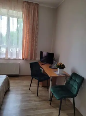 a room with a desk with two chairs and a computer at Svečių namai RASA in Raseiniai
