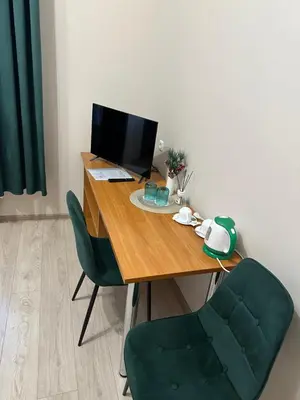 a wooden desk with a computer and a green chair at Svečių namai RASA in Raseiniai